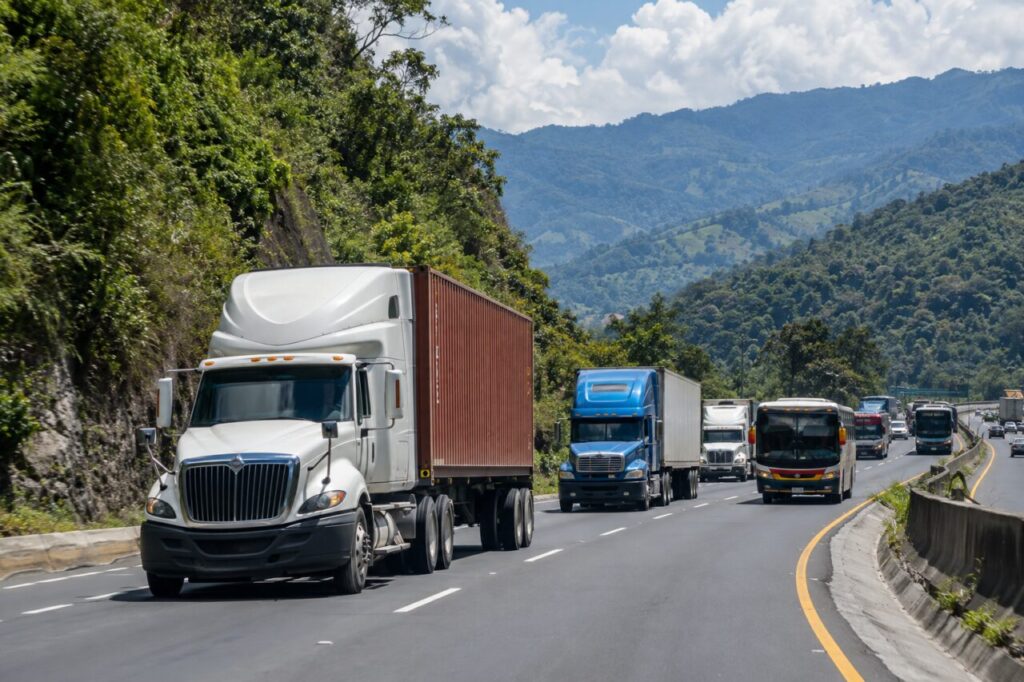Cabezal, camiones y bus circulando por una carretera de montaña en Guatemala